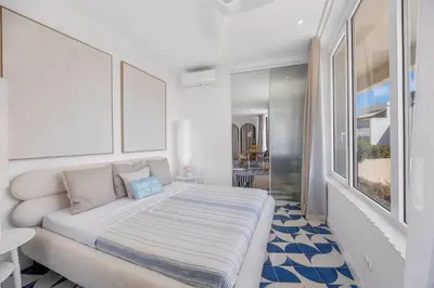 a white bedroom with a large bed in a room at Ocean Apartment by ENDLESS SUN I modern comfort, sea view, wi-fi, parking, heating in Lagos