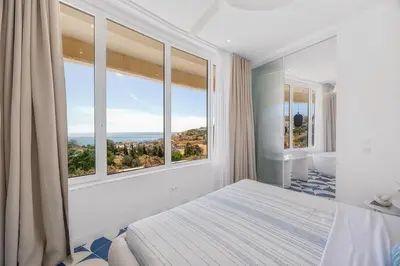 a bedroom with a large window with a view at Ocean Apartment by ENDLESS SUN I modern comfort, sea view, wi-fi, parking, heating in Lagos