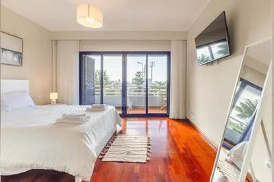a bedroom with a large bed and a sliding glass door at Suite Vista Mar in Funchal