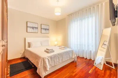 a bedroom with a bed and a large window at Suite Vista Mar in Funchal