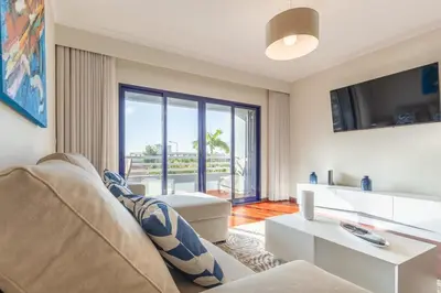 a living room with a couch and a tv at Suite Vista Mar in Funchal