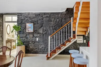 a staircase in a room with a stone wall at Villa Rosa Mare by Homie in Seixal