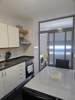 a kitchen with a counter and a table with chairs at Harbour View Apartment Free Parking in Funchal