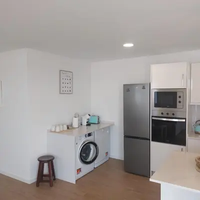 a kitchen with a refrigerator and a washing machine at Paradise Point Sea & Mountain view in Estreito da Calheta