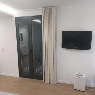 a room with a sliding glass door with a television at Paradise Point Sea & Mountain view in Estreito da Calheta