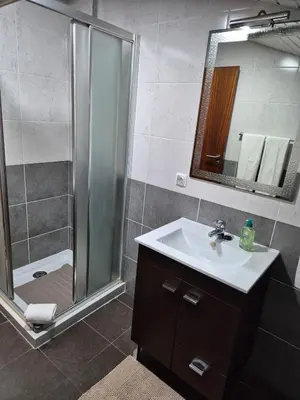 a bathroom with a shower and a sink and a mirror at North Coast View in Seixal