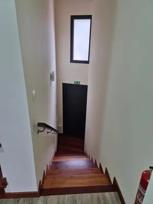 a stairway with a black door and a window at North Coast View in Seixal