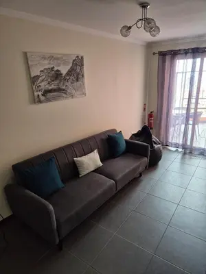 a living room with a brown couch in a room at North Coast View in Seixal