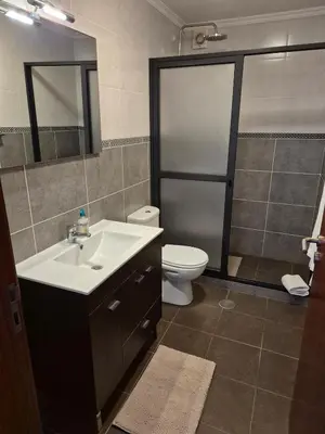 a bathroom with a sink and a toilet and a mirror at North Coast View in Seixal