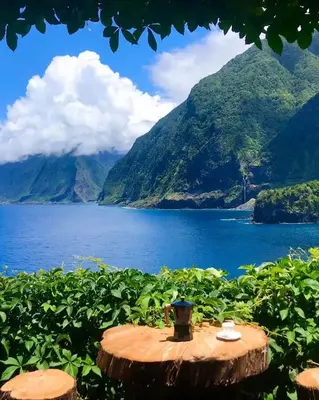 a table next to a body of water with mountains at North Coast View in Seixal