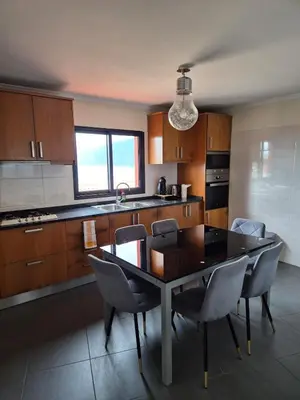 a kitchen with a table and chairs in a kitchen at North Coast View in Seixal