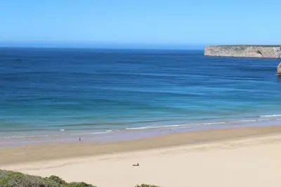 a group of people on a beach near the ocean at Beach front apartment 1 in Sagres