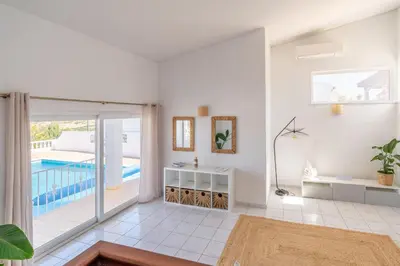 a living room with a view of a pool at Casa Dos Amigos in Budens