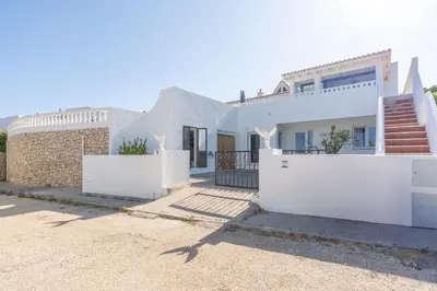 a house with white walls and a gate at Casa Dos Amigos in Budens