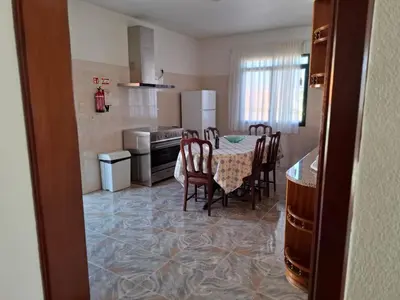 a kitchen with a table and chairs and a kitchen with a refrigerator at Casa Figo- Calheta in Calheta