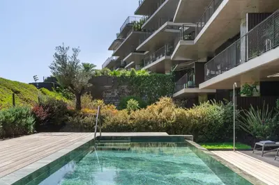a swimming pool in a garden next to a building at Savoy Monumentalis IX by An Island Apart in Funchal