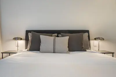 a white bed with pillows and two lamps on tables at Savoy Monumentalis IX by An Island Apart in Funchal