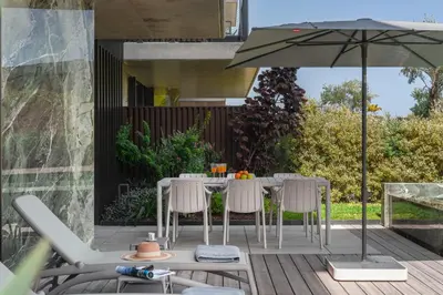 a patio with a table and chairs and an umbrella at Savoy Monumentalis IX by An Island Apart in Funchal