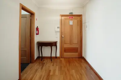 a hallway with a wooden door and a table at Home By SG in Funchal