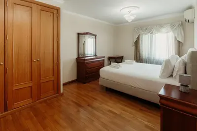 a bedroom with a bed and a dresser and a window at Home By SG in Funchal