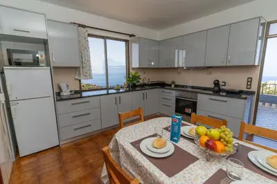 a kitchen with a table with a bowl of fruit on it at Vista al Mar in Ribeira Brava