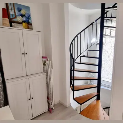 a black spiral staircase in a white room at Art House Funchalet in Funchal