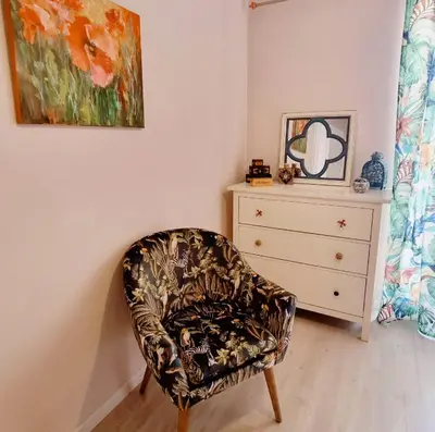 a chair in a room with a dresser and a painting at Art House Funchalet in Funchal