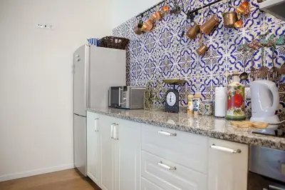 a kitchen with a white refrigerator and a blue and white wallpaper at Art House Funchalet in Funchal