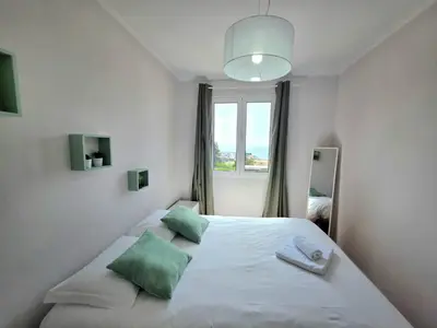 a bedroom with a large white bed with green pillows at Casa Dona by Rentallido in Funchal