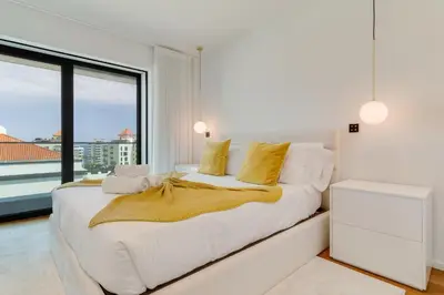 a bedroom with a large white bed with yellow pillows at OceanView Pearl Varino by Holiday Rental Madeira in Funchal