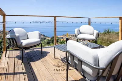 a house with an umbrella on a stone wall at Hilltop Hideaway by Escape to Madeira in Arco da Calheta