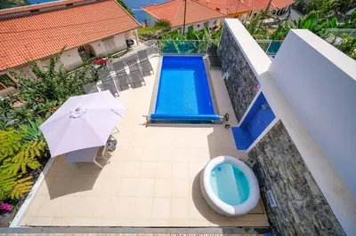 an overhead view of a swimming pool and an umbrella at Casa dos Amores in Calheta