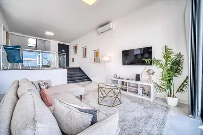 a living room with a couch and a tv at Casa dos Amores in Calheta