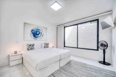 a white bedroom with a bed and a window at Casa dos Amores in Calheta