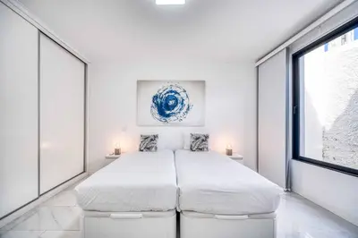 a white bedroom with a large bed and a window at Casa dos Amores in Calheta