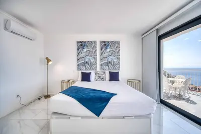 a bedroom with a king sized bed and a large window at Casa dos Amores in Calheta