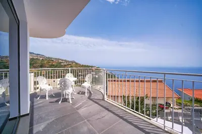 a balcony with chairs and a view of the ocean at Casa dos Amores in Calheta