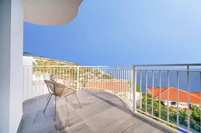 a balcony with a chair and a view of the ocean at Casa das Flores in Calheta