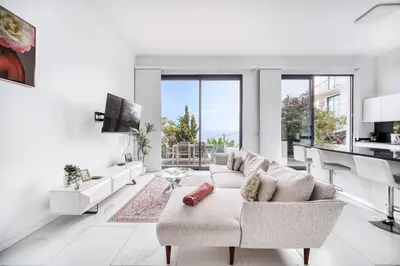 a white living room with a couch and a table at Casa das Flores in Calheta