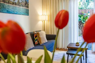 a living room with a blue couch and a table at Palm Tree by YOUR KEY in Caniço