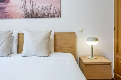 a bedroom with a bed and a lamp on a night stand at Palm Tree by YOUR KEY in Caniço