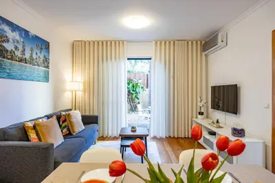 a living room with a couch and a table at Palm Tree by YOUR KEY in Caniço
