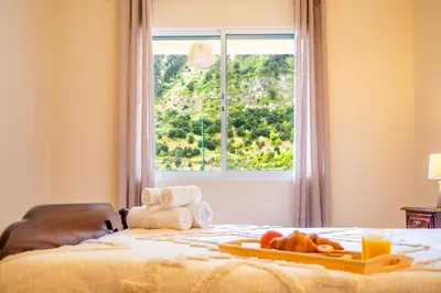a bed with a tray of fruit on it with a window at Villa Serrão, By OP in Ponta Delgada