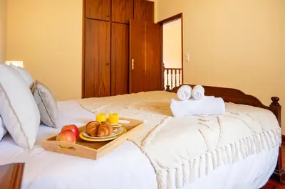 a tray of bread and fruit on a bed at Villa Serrão, By OP in Ponta Delgada