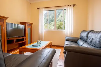 a living room with a couch and a television at Villa Serrão, By OP in Ponta Delgada