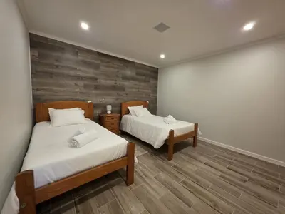 a bedroom with two beds and a large wall at Casa Dourada in Câmara de Lobos