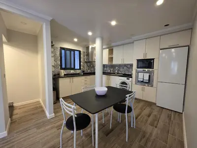 a kitchen with a black table and chairs and appliances at Casa Dourada in Câmara de Lobos
