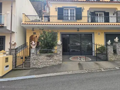 a house with a gate and a balcony at Casa Dourada in Câmara de Lobos