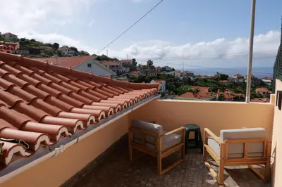a balcony with two chairs and a view of the ocean at Mill House in Ponta do Sol