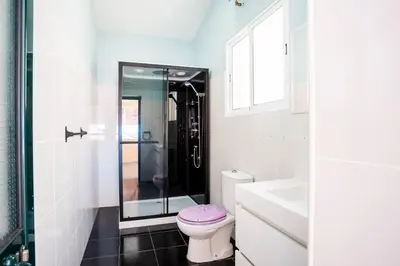 a bathroom with a toilet and a glass shower at Mill House in Ponta do Sol
